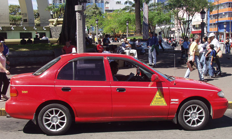 A red cab in Costa Rica with the official airport taxi logo
