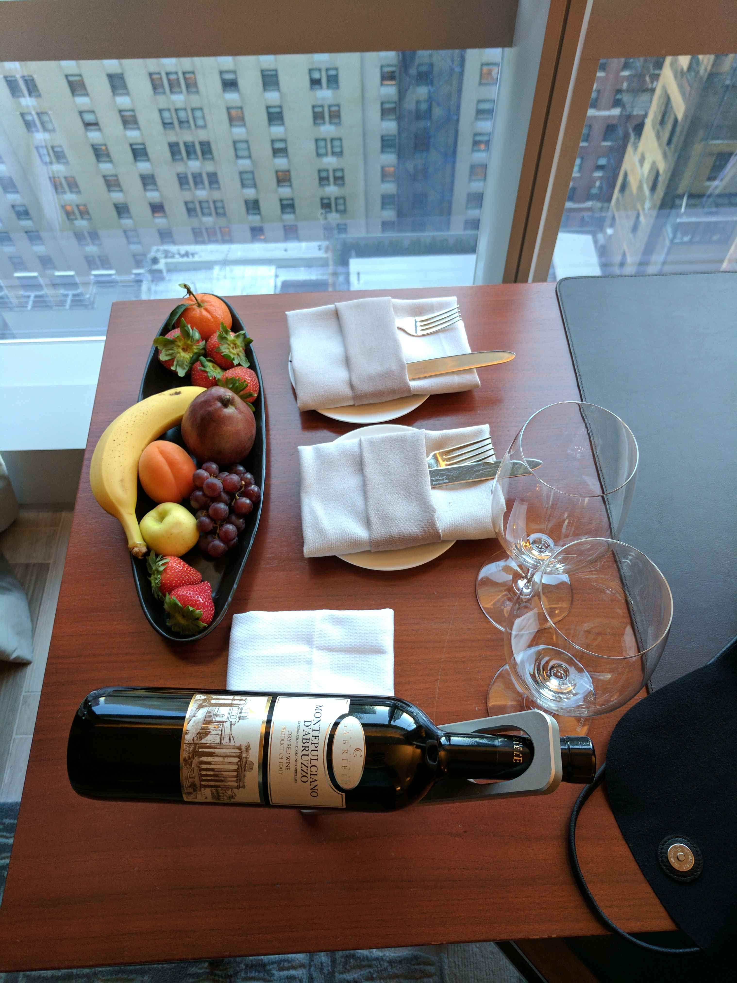 a table with a bottle of wine and fruit on it
