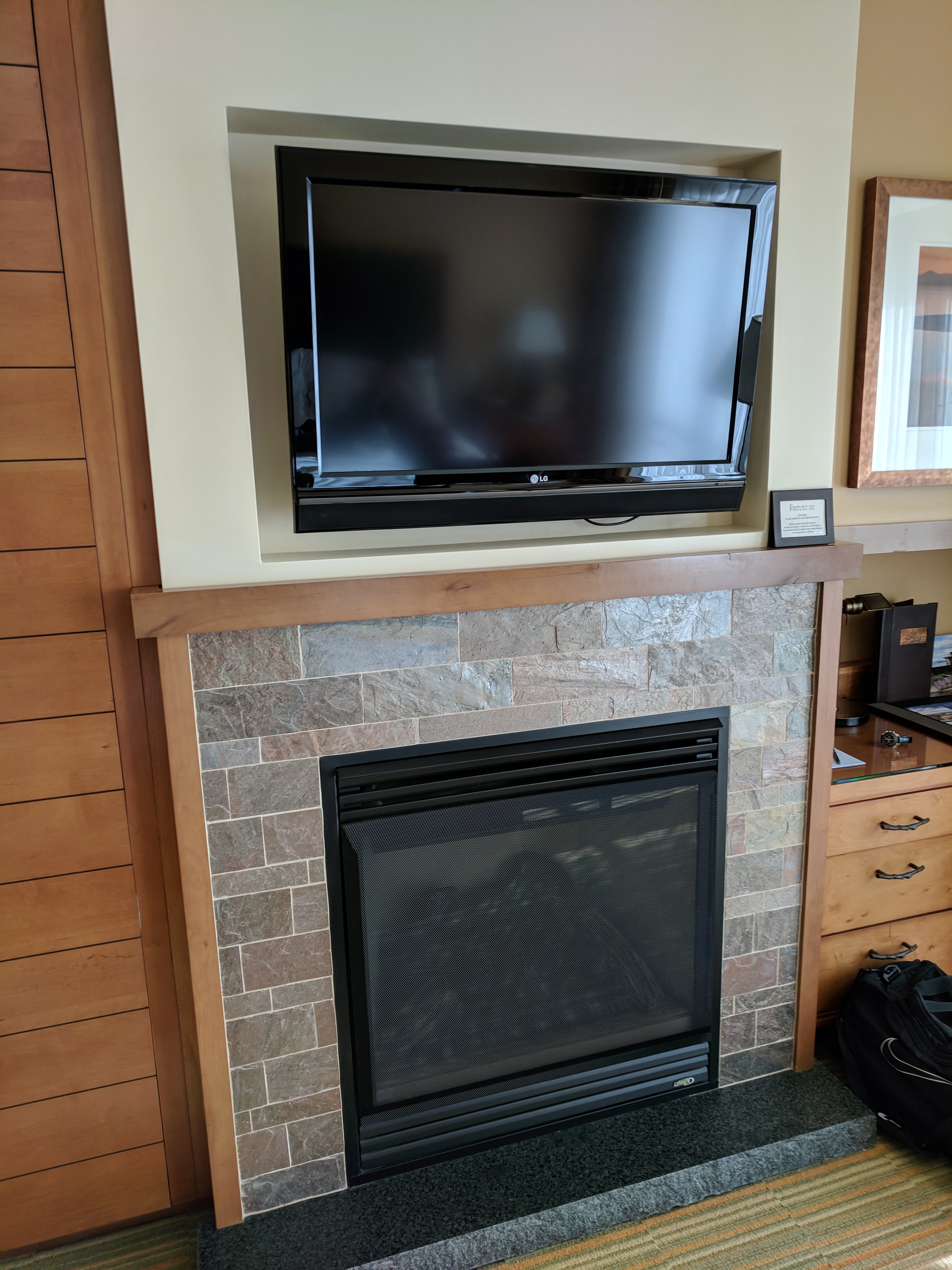 a tv on a wall above a fireplace
